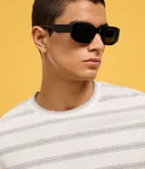 Remera de corte boxy con cuello redondo y mangas cortas. Presenta un diseño de rayas horizontales finas en tonos gris sobre fondo blanco.