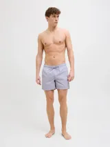 Short de baño de tiro medio en color lila, con cintura elástica y cordón ajustable. Presenta un diseño minimalista con el logo de la marca estampado en la parte inferior derecha.