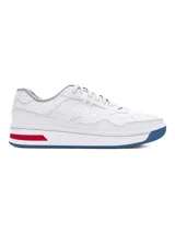 Zapatillas deportivas blancas para mujer, estilo tenis retro, con suela gruesa. Presentan detalles de color en la entresuela: una franja roja en el lateral y la suela exterior en color azul.