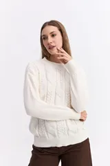 Buzo de punto color blanco, con cuello redondo y diseño de trama combinada con detalles trenzados. Presenta terminaciones tejidas en puños y ruedo.