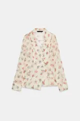 Camisa de cuello solapa y manga larga, con estampado de flores y cierre frontal cruzado.
