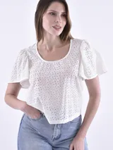 Blusa de broderie color blanco, con cuello redondo y mangas cortas con volados. Diseño de corte recto y estilo romántico.