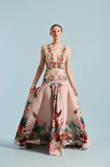 Vestido largo color rosado con escote en V pronunciado, sin mangas, talle ajustado con bordados florales y falda larga vaporosa con tajo frontal y estampado floral y de mariposas.