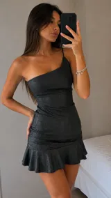 Vestido corto al cuerpo de un solo hombro, confeccionado en tela con acabado brillante. Presenta un diseño ajustado con un volado en el ruedo.
