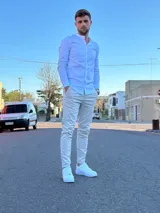 Camisa blanca de manga larga con cuello mao y cierre frontal con botones.