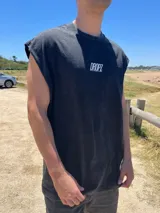 Musculosa de algodón con efecto lavado (acid wash) en color gris oscuro/negro, corte amplio sin mangas y cuello redondo. Presenta el logo "DROPZ" centrado en el pecho en color blanco.