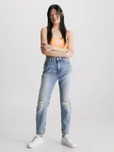 Pantalón de jean celeste claro, de corte mom, con roturas en las rodillas y ruedo desflecado.