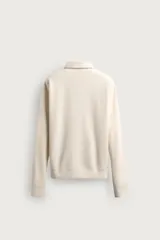 Polo de manga larga color gris oscuro, con diseño de textura estructurada, cuello solapa y cierre frontal de cremallera corta. Cuenta con puños y cintura de rib elástico.