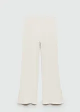 Pantalon de crochet color crema, de corte recto y tiro alto con cintura elástica. Presenta un diseño de tejido calado con aberturas laterales en el bajo.