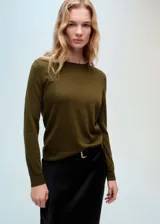 Sweater color verde oliva de tejido de lana, con cuello redondo y mangas largas. Diseño estándar y corte recto.