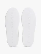 Zapatillas Tommy Hilfiger de diseño bajo color beige, con detalles en tono bordó en el talón y la lengüeta, suela blanca y logo distintivo de la marca en el lateral.