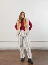 Pantalón de tiro alto con rayas verticales grises y blancas, corte recto y ruedo con dobladillo.