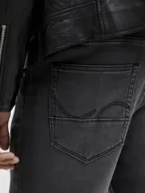 Jean tapered de hombre color negro con acabado lavado, tiro bajo y diseño clásico de cinco bolsillos.