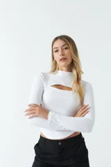 Top blanco de manga larga con cuello alto y abertura en el pecho. Corte ajustado y tejido elastizado.