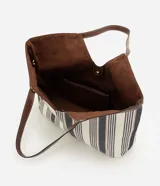 Cartera shopper de algodón con diseño a rayas en tonos neutros y detalles de ribetes y asas de hombro en PU marrón. Cuenta con una abertura central pronunciada y gran capacidad de almacenamiento.