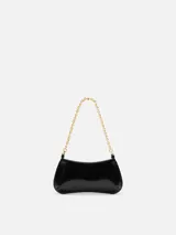 Cartera Le Petit Bisou Chaine de Jacquemus de cuero rojo, con silueta curva, correa de cadena dorada y logotipo metálico frontal.