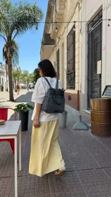 Cartera mochila de diseño versátil, color rosado, confeccionada en material sintético impermeable. Cuenta con doble asa superior, correas ajustables para usar como mochila, compartimento principal con cierre y bolsillo frontal con cierre decorado con tirador largo.