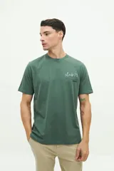 Remera verde militar de manga corta con estampado frontal que dice 'club-71'.