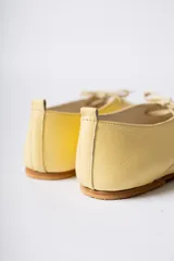 Zapato acordonado de cuero color negro, de diseño minimalista con punta cuadrada y silueta moderna.