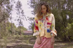 Chaqueta color beige con estampado abstracto en tonos amarillos, con cuello camisero, cierre frontal con botones, bolsillos plaqué y puños camiseros.