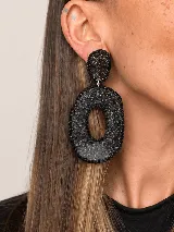 Aros colgantes artesanales de resina y metal plateado, con diseño texturizado en tonos celestes y plateados, adornados con bordes de strass.