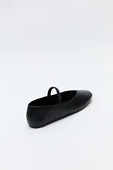 Balerina negra de cuero sintético con punta redondeada, escote en V y tira elástica sobre el empeine.