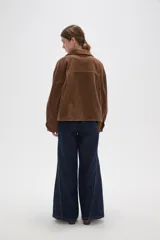Sobrecamisa de pana color verde oliva oscuro, con cuello clásico, cierre frontal con botones metálicos y dos bolsillos delanteros con solapa y botón.