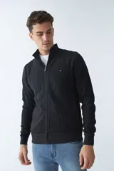 Campera negra de algodón con cierre completo, cuello alto, bolsillos laterales, puños y logo bordado en el pecho.