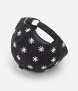 Gorra de sarga de algodón con visera curva y ajuste trasero. Presenta un estampado integral de margaritas blancas sobre fondo gris oscuro.