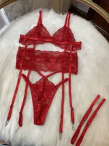 Conjunto de lencería de cuatro piezas en color rojo, confeccionado en encaje. Incluye bralette, tanga, portaligas y ligas regulables con enganches desmontables.