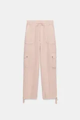 Pantalón cargo de tiro medio confeccionado en mezcla de lino. Presenta cintura con cordón ajustable, bolsillos de plastrón en el delantero y en las piernas, y bajo ajustable con cordones.