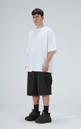 Remera de corte oversize color blanco, con cuello redondo y mangas cortas amplias. Presenta una costura horizontal decorativa en la parte media delantera.