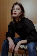 Blusa negra con cuello bebé con volados, mangas 3/4 abullonadas con lazo y botones blancos.