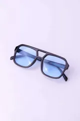 Lentes de sol con armazón geométrico negro y cristales celestes, modelo Cyrus con doble puente.
