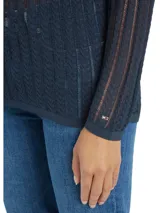 Sweater azul marino de tejido de punto calado con rayas verticales blancas, cuello polo y tapeta con tres botones.