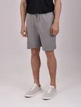 Bermuda de algodón color gris, con cintura elástica ajustable mediante cordón y bolsillo lateral tipo cargo con cierre.