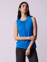 Musculosa negra de poliéster y elastano, con cuello redondo con frunces delanteros y abertura con botón en la espalda.