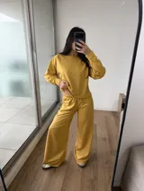 Conjunto de dos piezas compuesto por un buzo de cuello redondo y mangas largas con diseño reversible y un pantalón de corte ancho con cintura elástica.