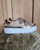 Zapatillas deportivas color beige con detalles en animal print y apliques metalizados. Cierre con velcro y suela blanca.