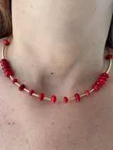 Gargantilla dorada con cuentas de coral rojo.
