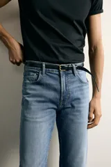 Jeans slim fit de color negro para hombre, con tiro medio, diseño de cinco bolsillos y cierre frontal con cremallera y botón.