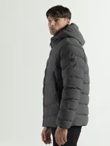 Campera acolchada con capucha integrada y cuello alto. Presenta cierre frontal completo, bolsillos laterales con cierre y puños con terminaciones elásticas para mayor protección contra el frío.