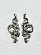 Aros colgantes con forma de serpiente blanca delineada con strass plateado.