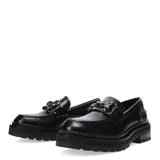 Zapato mocasín negro de cuero sintético con hebilla metálica plateada y suela track.