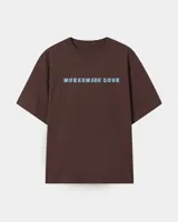 Remera marrón oversize con diseño gráfico estampado en la espalda que incluye la inscripción "Kaboa" y fechas de gira mundial.