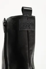 Bota tipo chelsea de caña media, color beige, con paneles laterales elásticos y suela track de plataforma dentada.