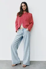 Blazer cruzado de tweed rojo con patrón texturizado en tonos blanco y negro, cuello con solapa, manga larga y cierre frontal con un botón.