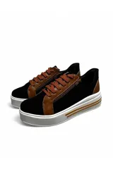 Championes deportivos Euroteens de plataforma, combinados en color negro con detalles en marrón tostado. Cuentan con cordones y cierre lateral decorativo, además de una suela gruesa blanca con línea tostada.
