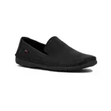 Zapato tipo mocasín o náutico de hombre, color negro, con costura artesanal visible alrededor del empeine y puntera. Presenta perforaciones tipo picado en la parte frontal y un pequeño detalle de etiqueta roja en el lateral.