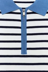 Sweater de punto con diseño a rayas horizontales en blanco y negro, manga larga, cuello polo en color celeste y cierre frontal parcial con cremallera.